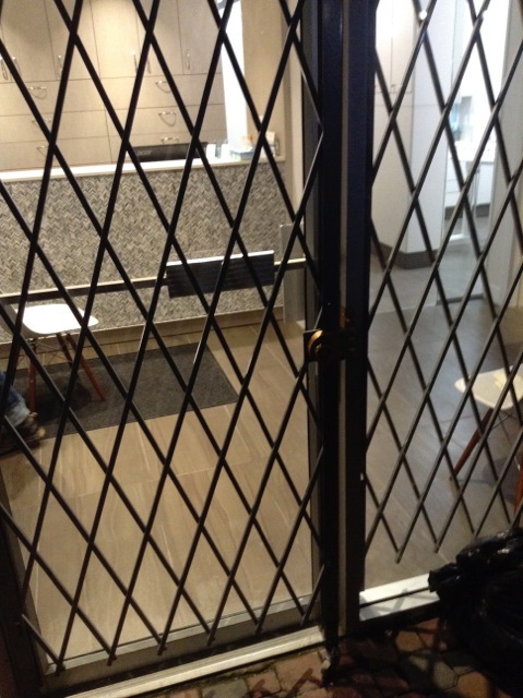 Expandable gate covering a door.